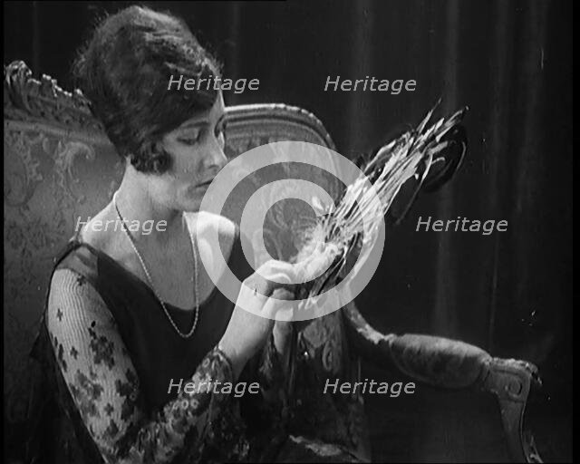Female Civilian Seating Handling a Fan Made of Feathers, 1920. Creator: British Pathe Ltd.