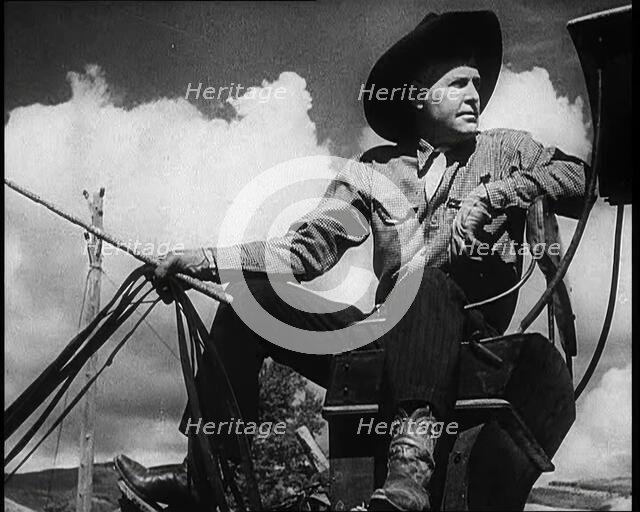 Male Civilian With a Cowboy Hat Sitting On a Coach Waiting For Passengers, 1932. Creator: British Pathe Ltd.