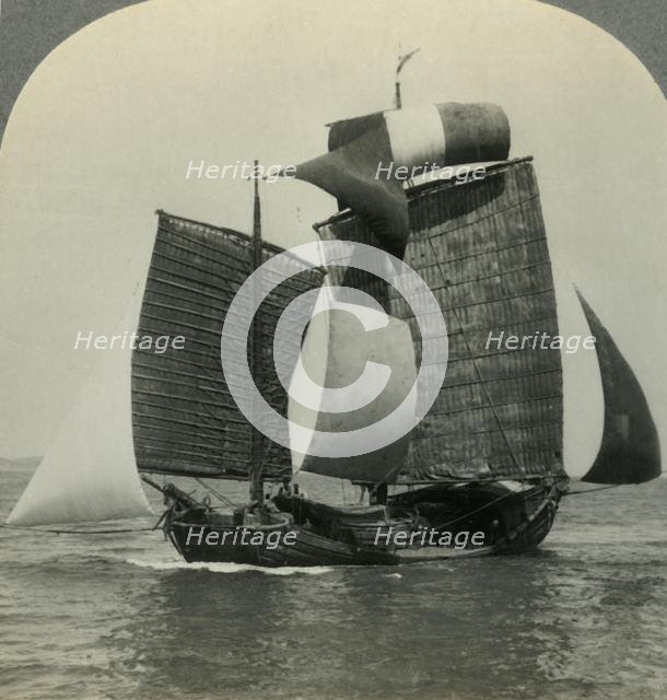 'Picturesque Chinese Junk under Full Sail on the Yellow Sea, Coast of Manchukuo in Distance', c1930s Creator: Unknown.