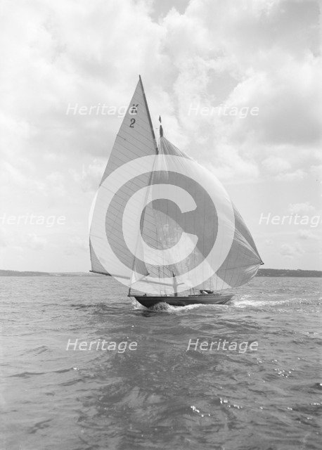 The 7 Metre yacht 'Ithnan' (K2) sailing with spinnaker, 1912. Creator: Kirk & Sons of Cowes.