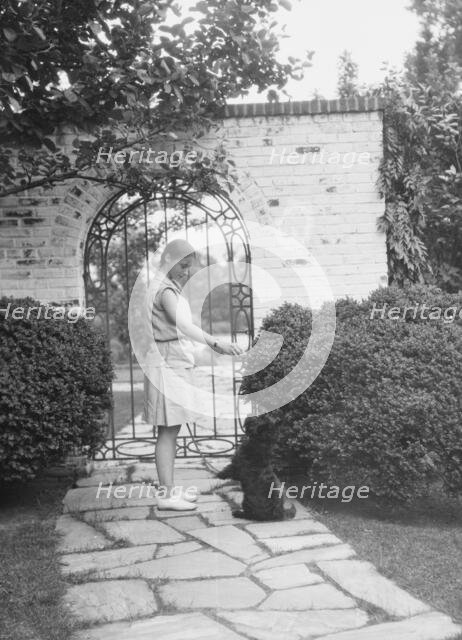 Brady, Genevieve, Miss, with dog, standing outdoors, between 1928 and 1931. Creator: Arnold Genthe.