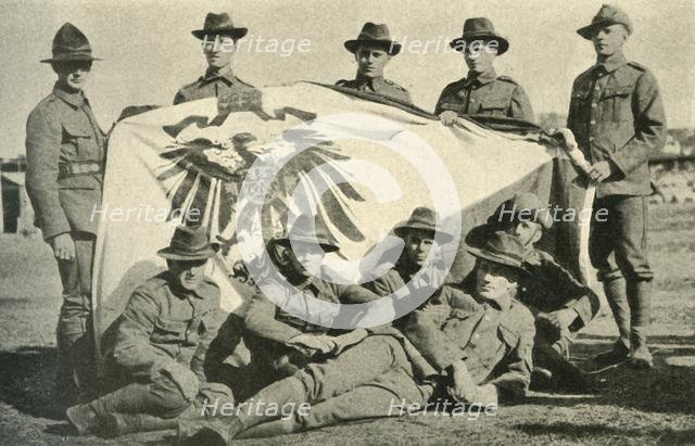 New Zealand soldiers with captured German flag, First World War, 1914, (c1920). Creator: Unknown.