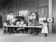 Eight African American children, in kindergarten, learning washing and ironing..., 1899 or 1900. Creator: Frances Benjamin Johnston.