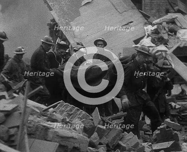 Firefighters Carrying Out a Corpse from a Bombed Out Building, 1940. Creator: British Pathe Ltd.