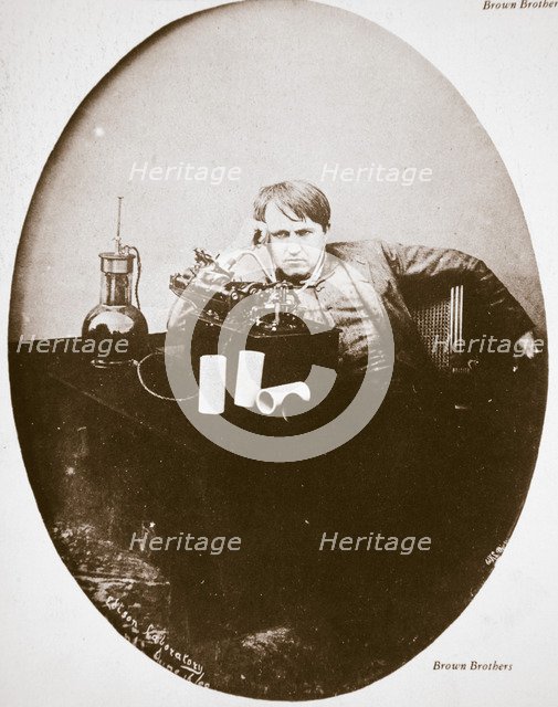 Thomas Alva Edison, American inventor, sitting beside his improved machine, 1889. Artist: Unknown