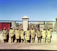 Group of labourers in front of a chain-link fence, between 1905-1915. Creator: Sergey Mikhaylovich Prokudin-Gorsky.