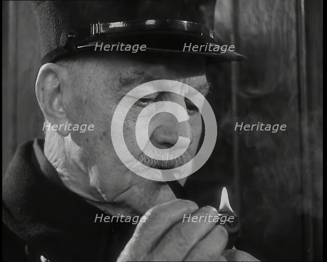 Close up on Male British Chelsea Pensioner as He is Lighting a Pipe, 1939. Creator: British Pathe Ltd.