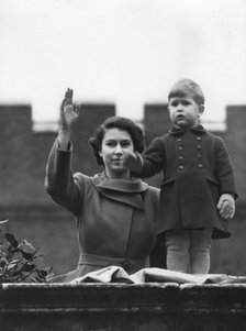 Princess Elizabeth and a two year old Prince Charles wave from Buckingham Palace, 1950.   Creator: Unknown.