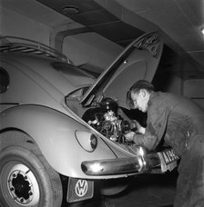 Car mechanic servicing a Volkswagen, Vallingby, Sweden, 1956. Creator: Unknown.