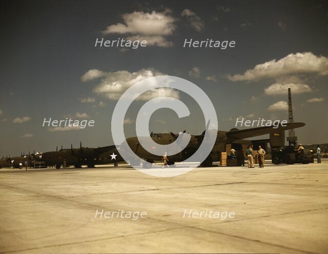 Consolidated transport planes being loaded, Consolidated Aircraft Corp., Fort Worth, Texas, 1942. Creator: Howard Hollem.