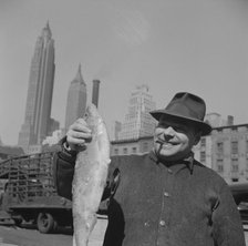 Fisherman holding a large catch at the Fulton fish market, New York, 1943. Creator: Gordon Parks.