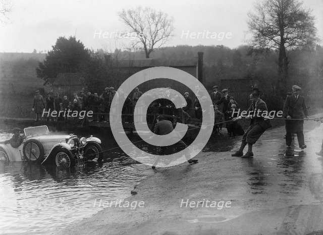 1935 Frazer-Nash TT replica being pulled out of a ford during a motoring trial, 1936. Artist: Bill Brunell.