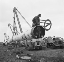 The Fens gas pipeline being lifted by a row of Caterpillar 583 pipelayers, Norfolk, 20/09/1967. Creator: John Laing plc.