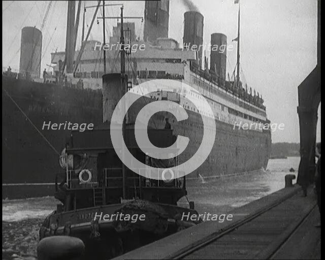 A Tugboat Pulling an Atlantic Liner into a Harbour, 1920s. Creator: British Pathe Ltd.