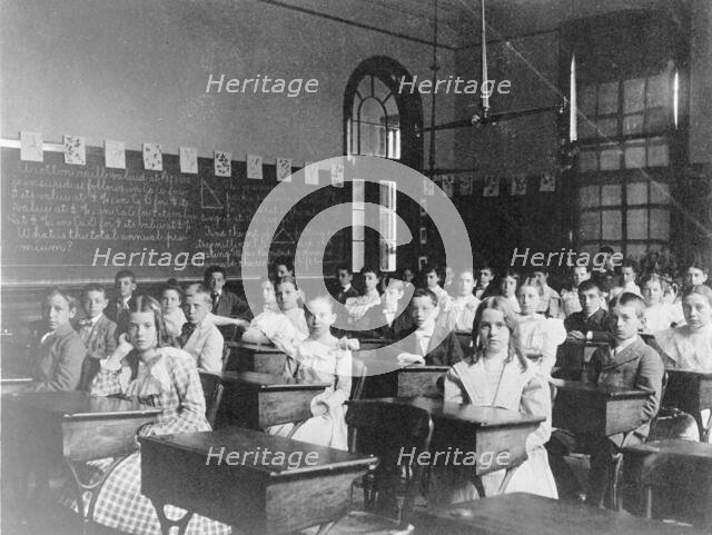 Girls and boys seated at desks in Washington, D.C. classroom, (1899?). Creator: Frances Benjamin Johnston.