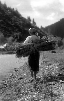 Woman carrying a bundle of sticks, Bistrita Valley, Moldavia, north-east Romania, c1920-c1945. Artist: Adolph Chevalier