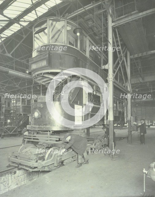 Men using a car lifting hoist at Charlton Central Repair Depot, London, 1932.  Artist: Unknown.