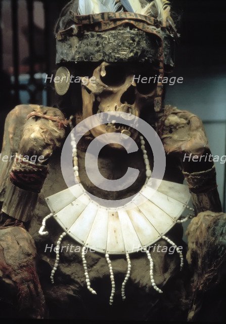 Mummy with gold headdress and tissue.