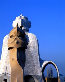 Detail of the chimneys of La Pedrera or Mila House with the Sagrada Familia at background, work b…