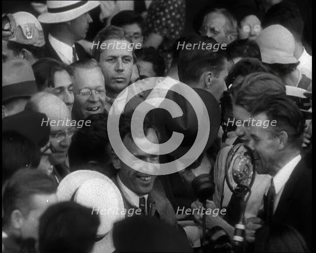 Jim Mollison Walking Surrounded by a Large Crowd, 1930s. Creator: British Pathe Ltd.