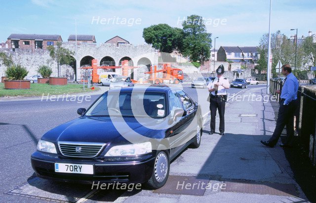 Policeman checking driver documents. Artist: Unknown.