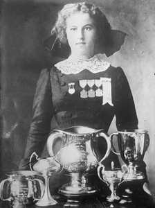 Alsie Aykroyd in front of her trophies, 1910. Creator: Bain News Service.