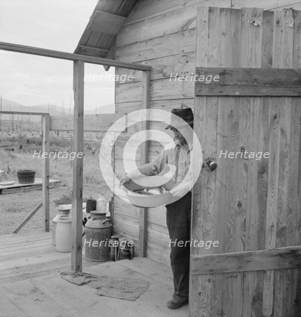 New settler shows fish he caught this morning, Priest River Valley, Bonner County, Idaho, 1939. Creator: Dorothea Lange.