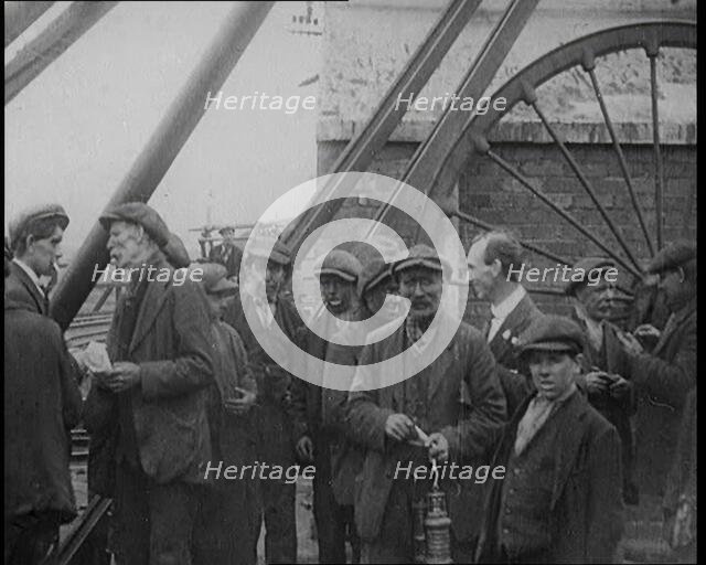 A Group of Miners Gathering and Smoking at a Pit Head, 1920. Creator: British Pathe Ltd.
