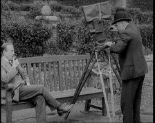 A Newsreel Camera Filming British Prime Minister Stanley Baldwin Sitting On a Bench in the..., 1924. Creator: British Pathe Ltd.