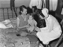 Nurse attending sick baby, FSA camp, Farmersville, Tulare County, California, 1939. Creator: Dorothea Lange.