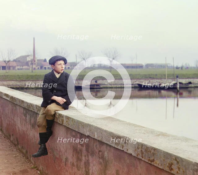 Boy sitting on sea wall, between 1905 and 1915.  Creator: Sergey Mikhaylovich Prokudin-Gorsky.