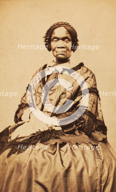 Three-quarter length portrait of unidentified woman dressed with long-fringed shawl, c1870-c1879. Creator: George W Hennigar.