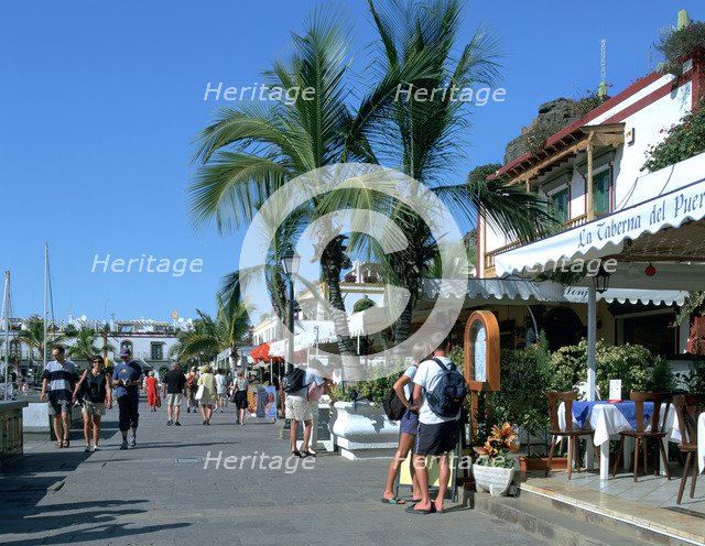 Tourists checking out a restaurant menu, Puerto de Mogan, Gran Canaria, Canary Islands.