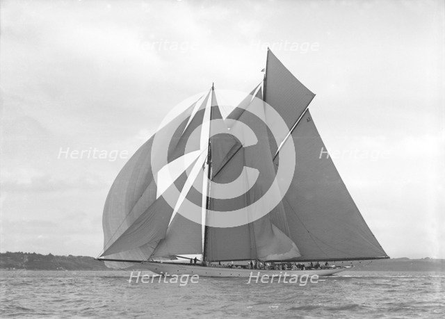 The 250 ton schooner 'Germania' sails downwind under spinnaker, 1911. Creator: Kirk & Sons of Cowes.