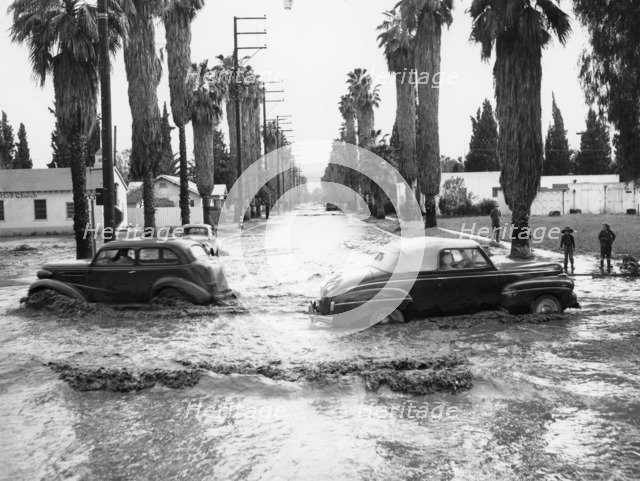 Cars on a flooded road in California, USA. Artist: Unknown