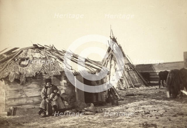 Tatar couple with a small boy in front of their home, between 1885 and 1886. Creator: Unknown.