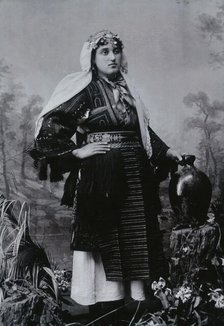 A Bulgarian woman in national dress with a water jug, early 20th century. Creator: Unknown.