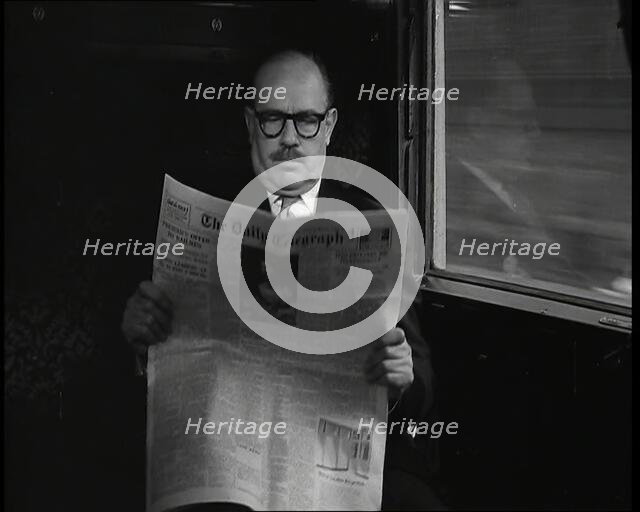 A Bald Man Wearing Spectacles Reading 'The Daily Telegraph' in the Carriage of a Train..., 1938. Creator: British Pathe Ltd.