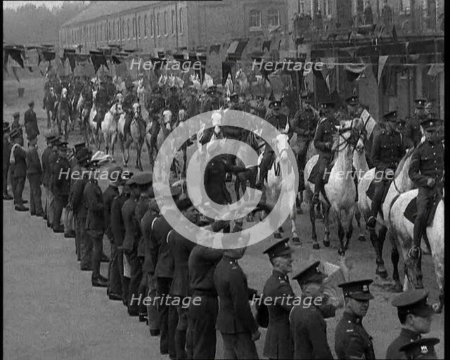 Military Parade of Mounted British Soldiers Riding Down a Street Decorated With Bunting, 1937. Creator: British Pathe Ltd.