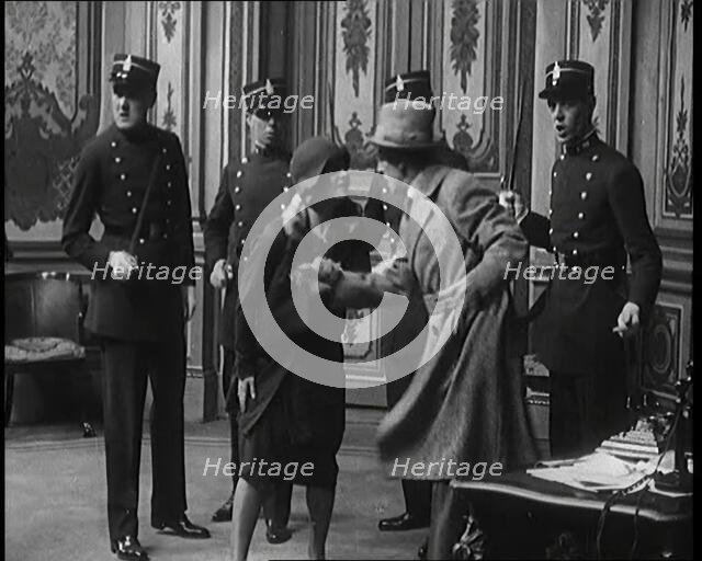 The Actor Gene Gerrard Hand Cuffed to His Co Star Being Watched By French Police They..., 1920s. Creator: British Pathe Ltd.