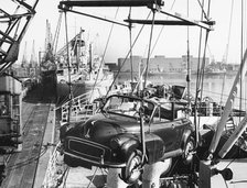 Morris Minor convertible craned onto ship for export at Cardiff docks. Creator: Unknown.