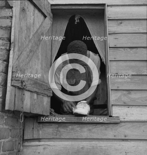 Negro field hand getting ready to go to town on a Saturday afternoon, 1937. Creator: Dorothea Lange.