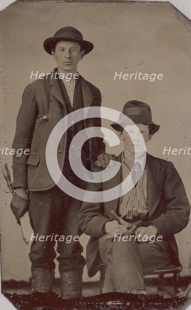 Two Young Men, One Seated and One Standing, Holding Carpentry Tools, 1870s-90s. Creator: Unknown.