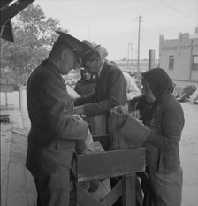 Plant quarantine inspectors examining goods bought... before entering El Paso, Texas, 1937. Creator: Dorothea Lange.