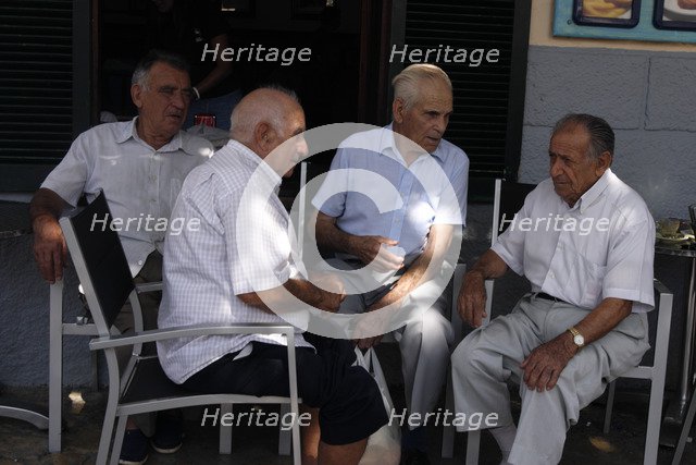 Group of men chatting at Pollensa Sunday market, Mallorca, Spain.
