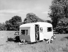 Couple on holiday with their 1963 Sprite Alpine caravan, (c1963?). Artist: Unknown