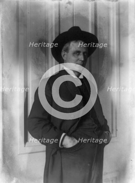 Champ Clark, half-length portrait, standing, facing right, hands in pants pockets, (1898?). Creator: Frances Benjamin Johnston.