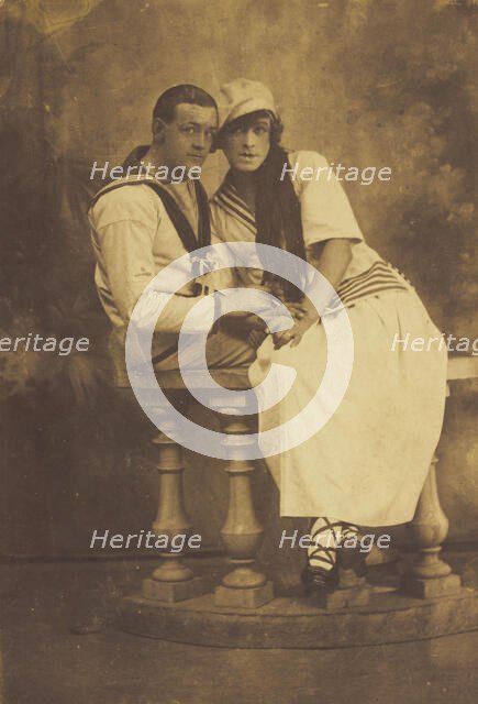 Two sailors, one in drag, embracing while sitting on a stage balcony, (between 1910 and 1919?). Creator: Unknown.
