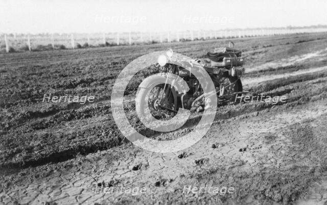 Motorbike in mud, near Dalby, Queensland, 1930. Creator: Jack Bain.