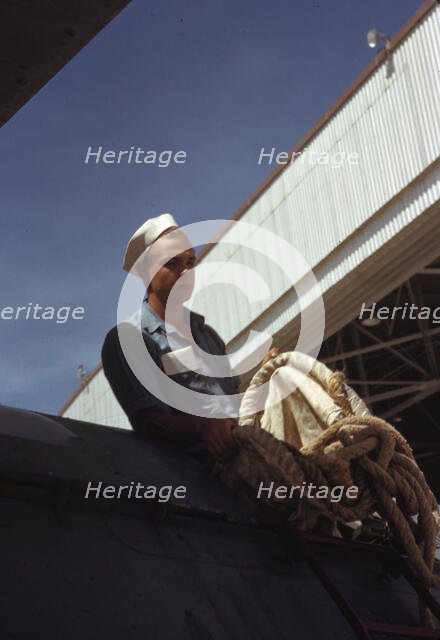 Sailor mechanic inspecting a PBY plane at the Naval Air Base, Corpus Christi, Texas, 1942. Creator: Howard Hollem.